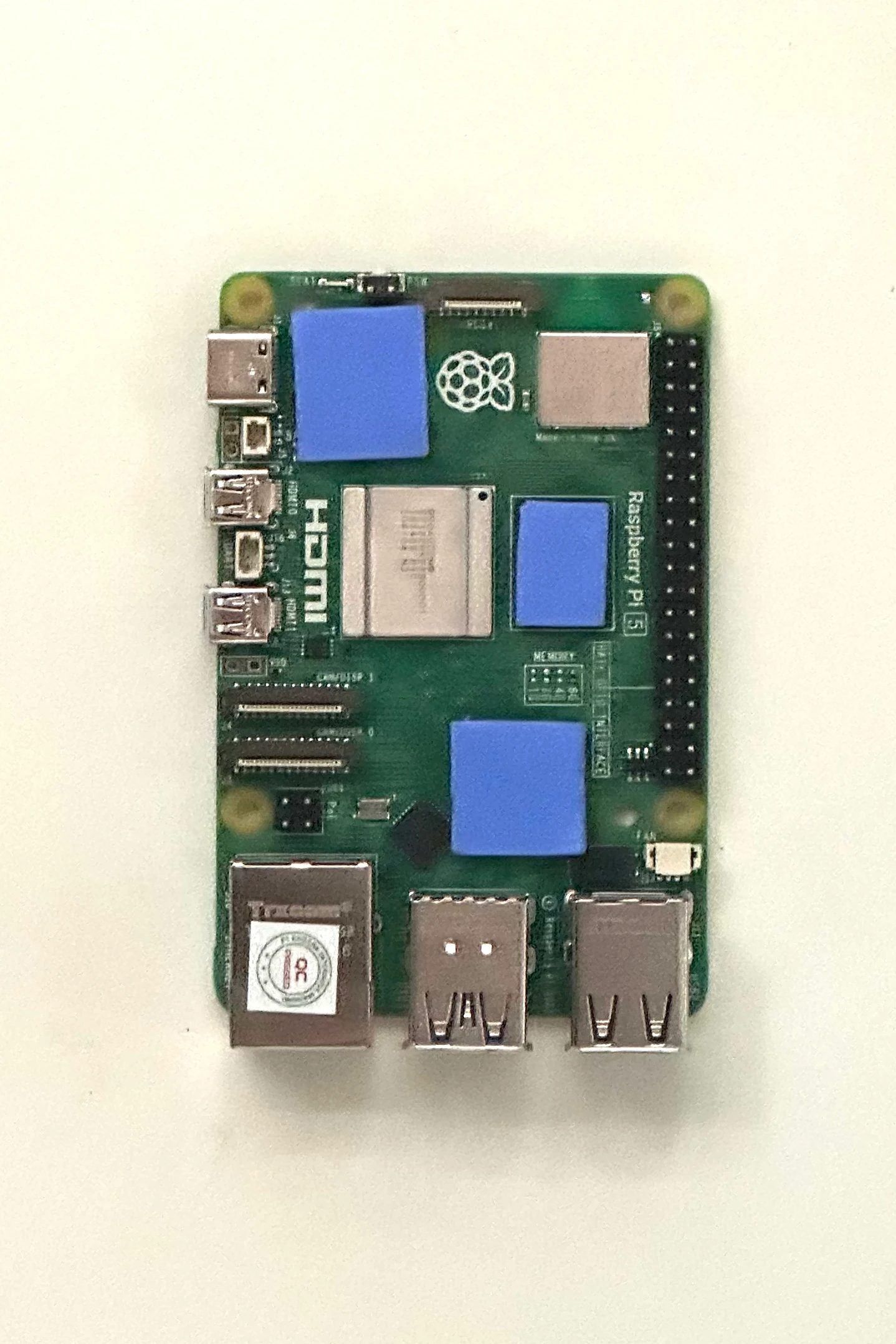 The Raspberry Pi 5 with three blue thermal pads on its chips